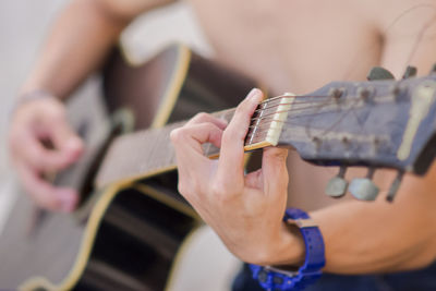 Midsection of person playing guitar