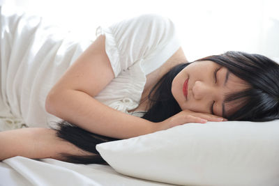 Young woman sleeping on bed at home