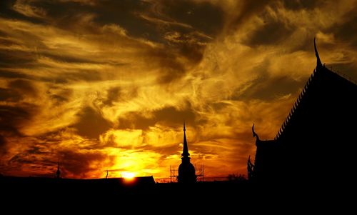 Silhouette of building against dramatic sky