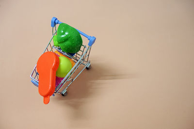 High angle view of toys in miniature shopping cart on table