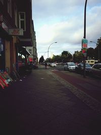 Cars on street in city against sky