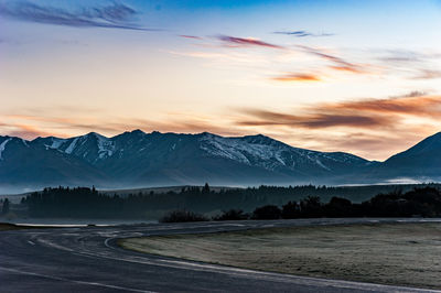 Scenic view of snowcapped mountains against sky during sunset