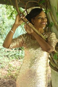 Smiling woman in shiny dress posing outdoors