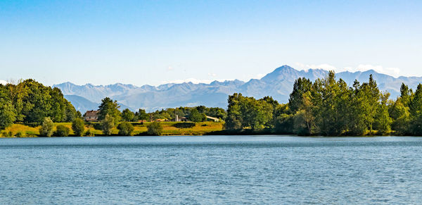 Scenic view of lake and mountains against clear sky