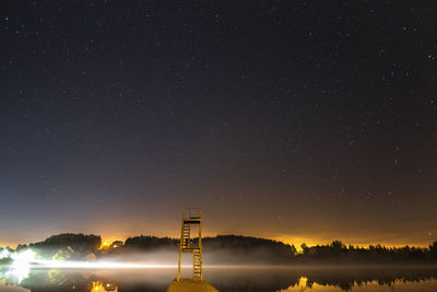 Illuminated tower against sky at night