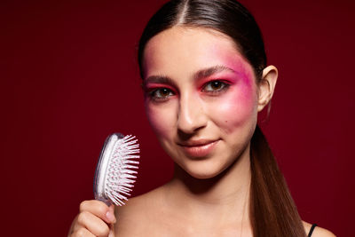 Close-up of young woman against black background