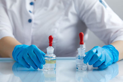 Midsection of scientist examining chemical in laboratory