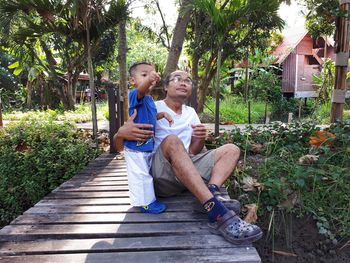 Full length of father and son on footbridge at park