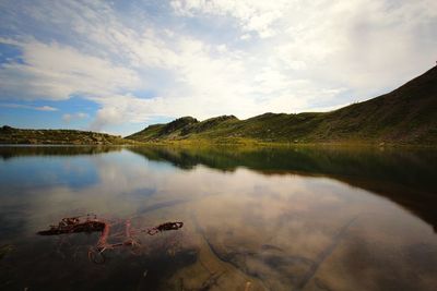 Scenic view of lake by mountain against sky