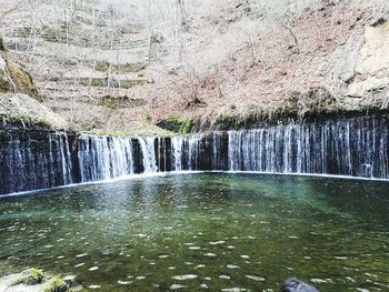 Scenic view of waterfall against trees