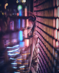 Portrait of young woman in nightclub seen through glass