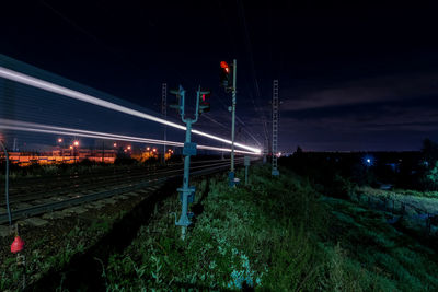 Train on railroad tracks against sky at night