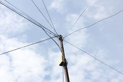 Low angle view of pole against cloudy sky