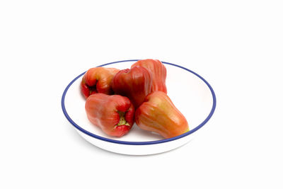 High angle view of fruits in plate against white background