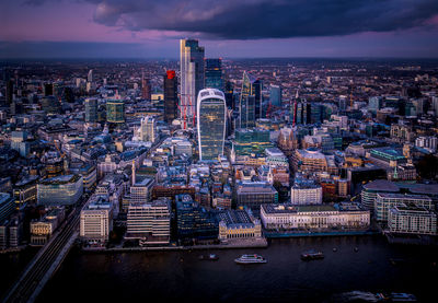 High angle view of city buildings against cloudy sky