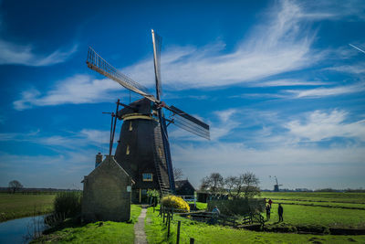 Traditional windmill on field against sky
