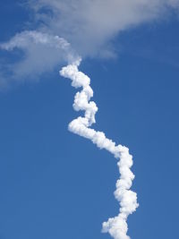 Low angle view of vapor trail against blue sky