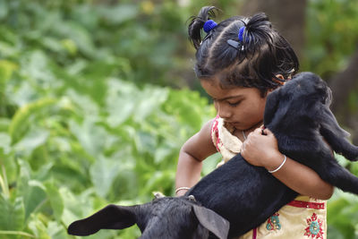 Close-up of girl holding kid goat