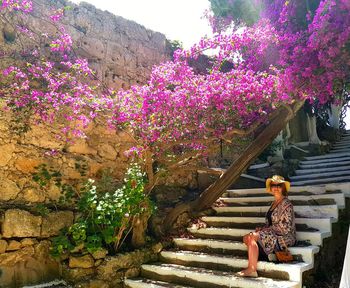 Woman sitting on pink flowering plant