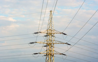 Low angle view of electricity pylon against sky