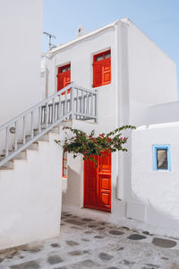 Traditional whitewashed house with red details in mykonos town, mykonos, greece.