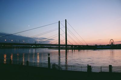 Bridge over river in city against clear sky