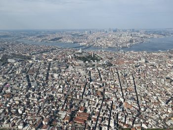 High angle view of townscape by sea against sky