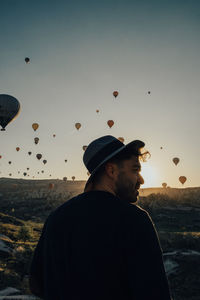 Man standing on hot air balloon against sky