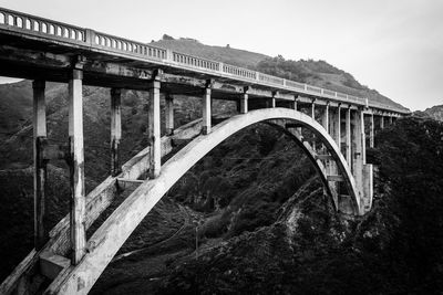 Arch bridge over river against sky