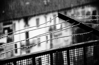 High angle view of metallic cables on railing in rain