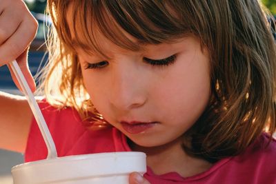 Close-up of girl eating food in container