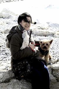 Woman playing with dog on snow