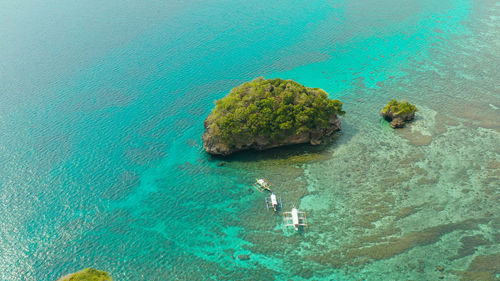 Clear turquoise water in a lagoon with rocky islands and corall reef from above boracay, philippines