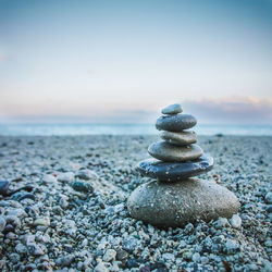 Stack of stones on beach against sky