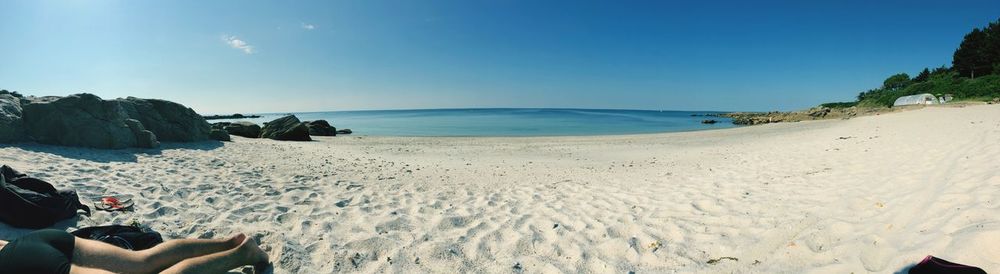 Low section of person on beach against sky