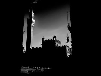 Low angle view of silhouette buildings against sky in city