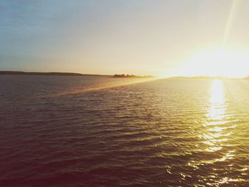 Sun shining through clouds over sea