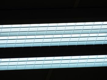 Low angle view of building against sky seen through window