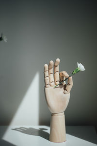 Close-up of white flower vase on table against wall