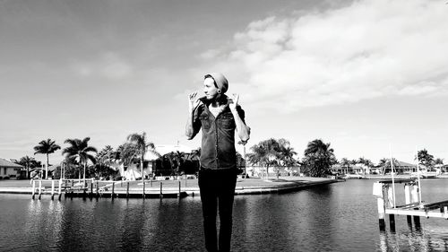 Woman standing by tree against sky
