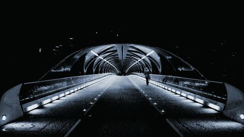 Illuminated bridge against sky at night