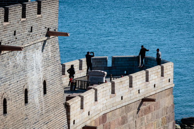 People by sea against blue sky