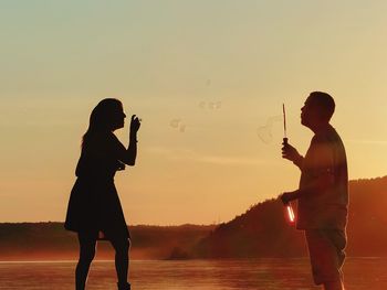 Side view of a man drinking water at sunset