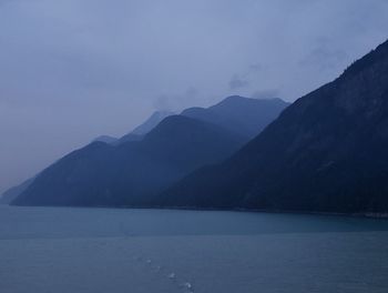 Scenic view of sea and mountains against sky