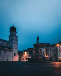 Illuminated buildings against sky at dusk