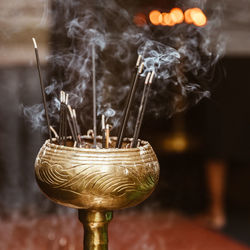 Close-up of lit candle in temple