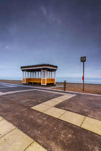 Built structure on road by sea against sky