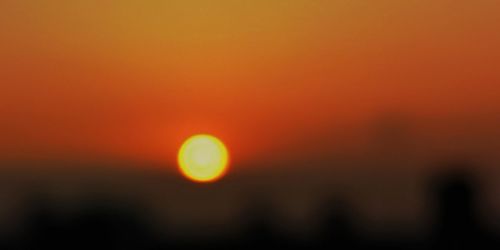 Defocused image of silhouette landscape against romantic sky at sunset