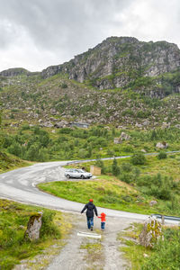 Rear view of man on road against mountain range