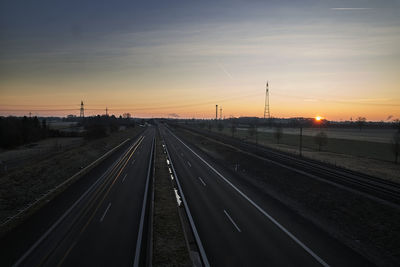 Railroad tracks against sky during sunset
